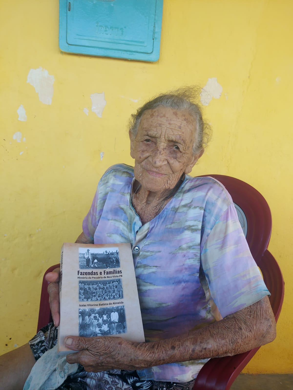 Anciã com livro da história local